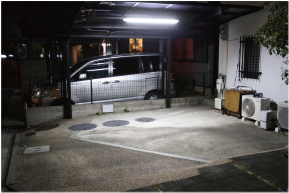 屋外用ＬＥＤ照明フィールドライトを自宅駐車場中央上側に設置し、全体が明るくなっている画像